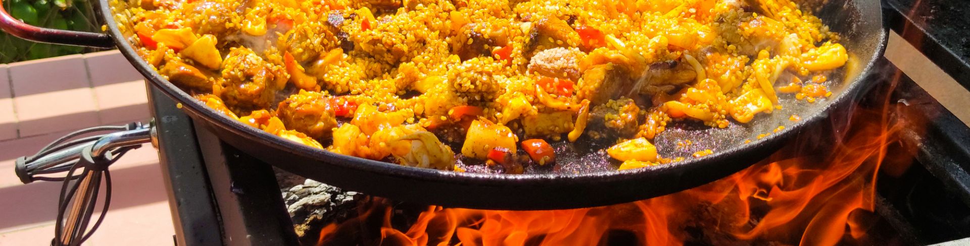 A close-up look at the traditional Spanish dish of paella being cooked on an open fire.