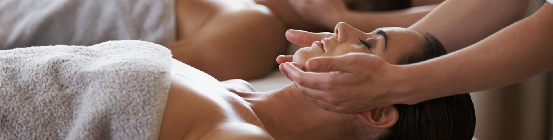 A couple receiving massages in a spa.