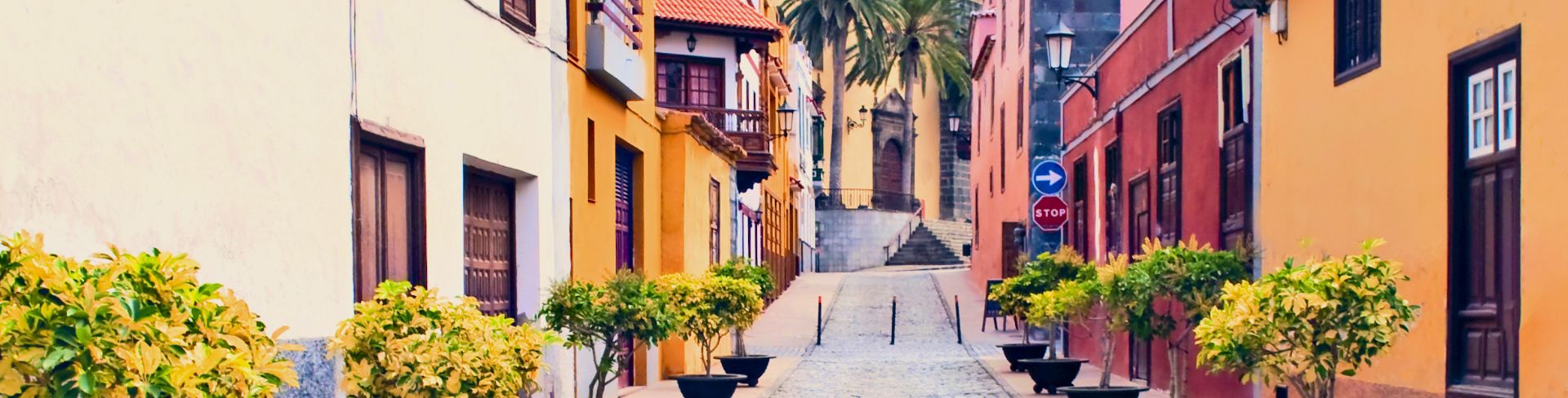 A cobblestone street lined by colorful Mediterranean-style buildings.