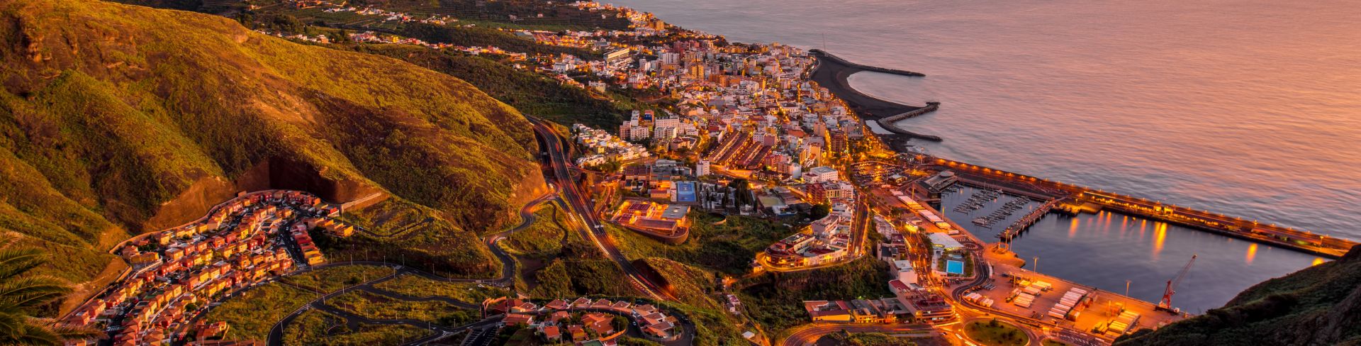 The view of Santa Cruz de Tenerife's cityscape from a mountain at dusk.