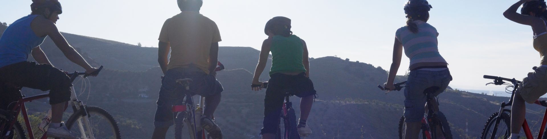 Five cyclists taking a break on a countryside trail.