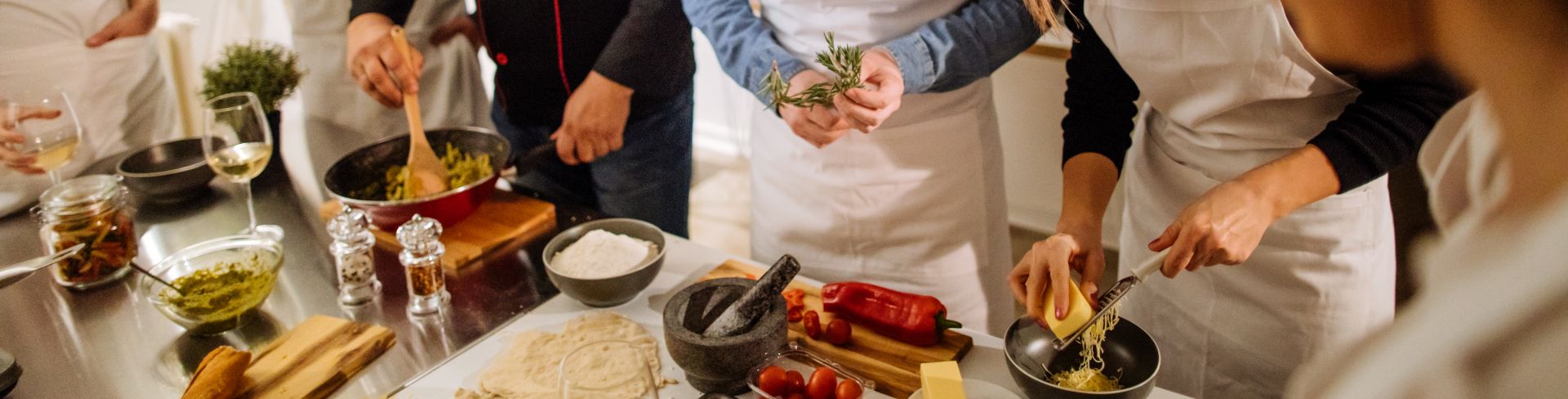 A chef and his students in a kitchen during a cooking class.