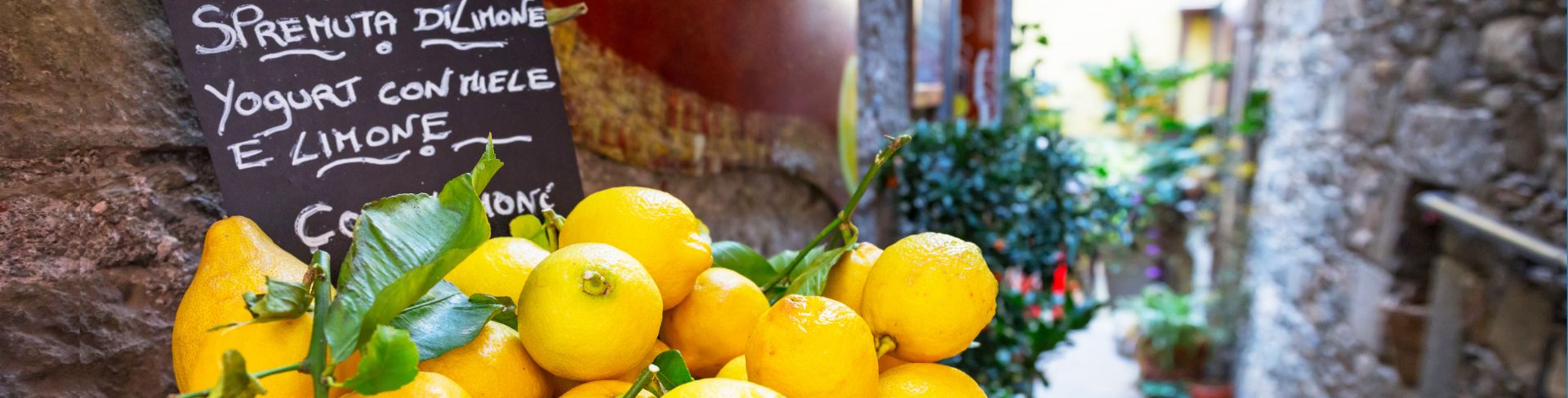 A wicker basket full of lemons on an Italian side street.