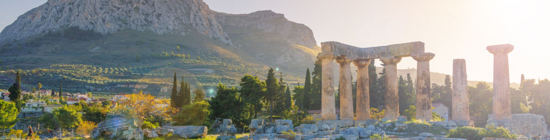 Ancient ruins surrounded by trees and mountains