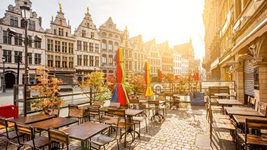 Sun shining brightly on an outdoor restaurant on an Antwerp street.