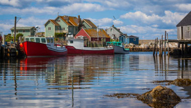 Brightly colored buildings reflecting on the deep tranquil water.