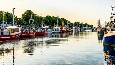 Fishing boats sit docked along the side of a canal.