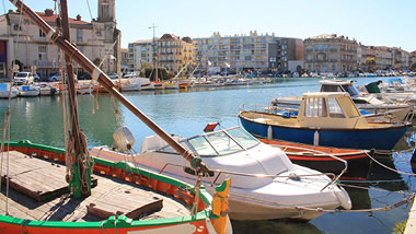 Fishing boats sit docked along the side of a canal.