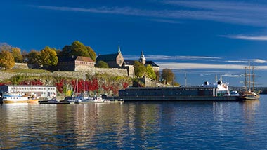 The deep blue sea reflects the houses perched along the shore.