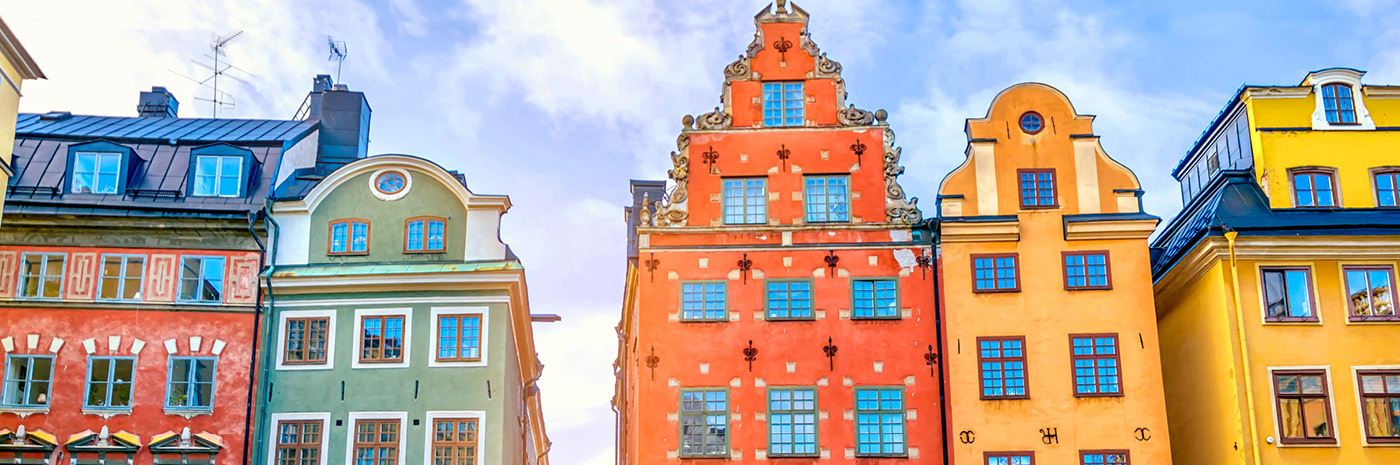 Colorful buildings lined up facing the sun.
