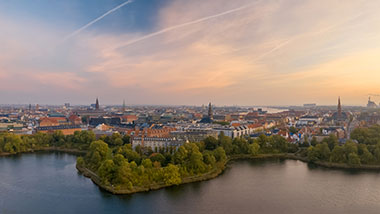 Hazy pastel morning cityscape panorama of Copenhagen at sunrise.