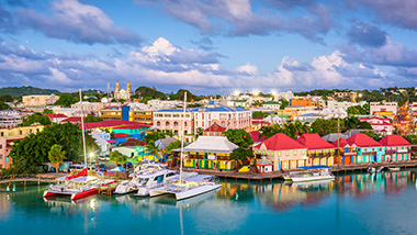 Brightly colored houses sit at the water's edge, where boats are docked.