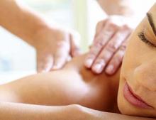 A woman receives a massage in a sunlit room.